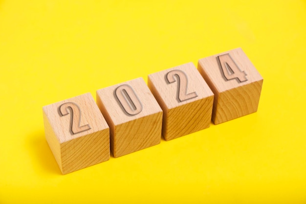 Cubes en bois avec numéros 2024 fond jaune