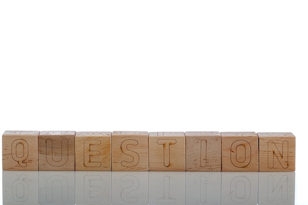 Cubes en bois avec question de lettres sur fond blanc