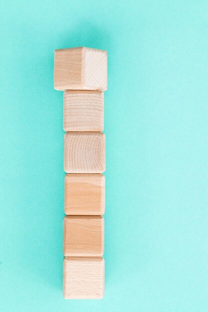 Cubes de formes géométriques en bois isolés sur fond bleu