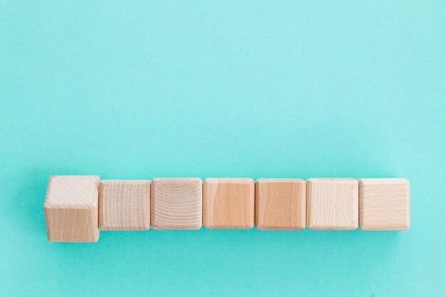 Cubes de formes géométriques en bois isolés sur fond bleu