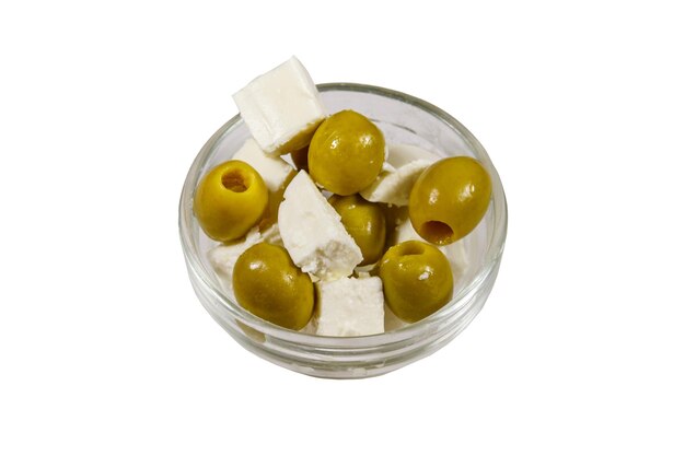 Cubes de fromage feta aux olives vertes dans un bol en verre isolé sur fond blanc