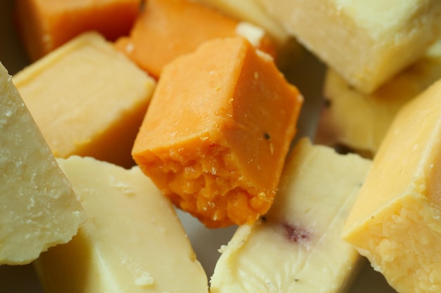 Cubes de fromage vert jaune et rouge sur planche à découper