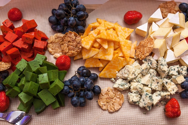 Cubes de fromage vert rouge avec des fruits sur la table