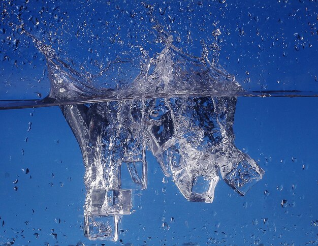 Cubes de glace éclaboussant dans l'eau libre