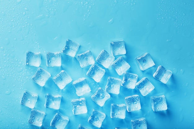 Cubes de glace avec des gouttes d'eau éparpillées sur une vue de dessus de fond bleu