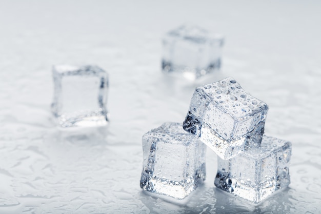 Cubes de glace sous la forme d'une pyramide avec des gouttes d'eau close-up en macro sur fond blanc.