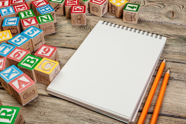 Cubes de lettres. Cubes en bois avec des lettres avec cahier vierge