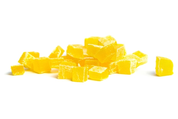 Des cubes de mangue séchés isolés sur un fond blanc, un gros plan de mangue en dés, un tas de fruits sucrés.