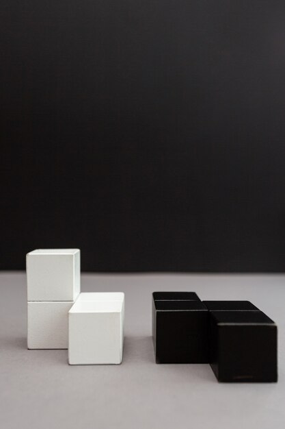 Cubes noirs et blancs sur fond gris-noir. Puzzle en bois.