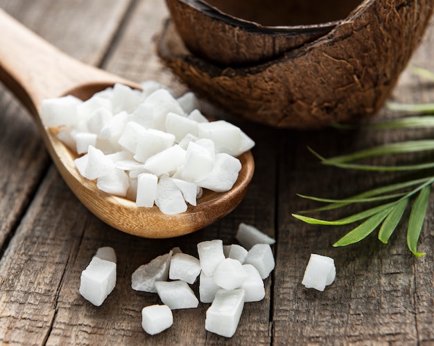 Cubes de noix de coco séchées dans une cuillère sur la surface de la table en bois