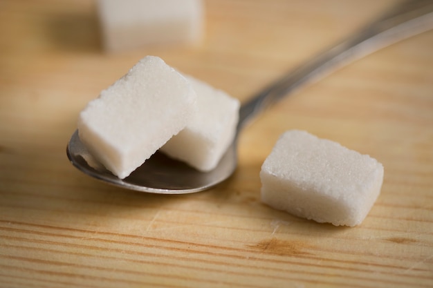 Des cubes de sucre et une cuillère sur la table