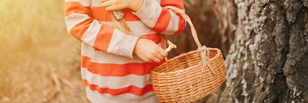 Photo la cueilleur de champignons pour enfants est à la recherche et à la cueillette de champignons avec un panier dans la forêt d'été