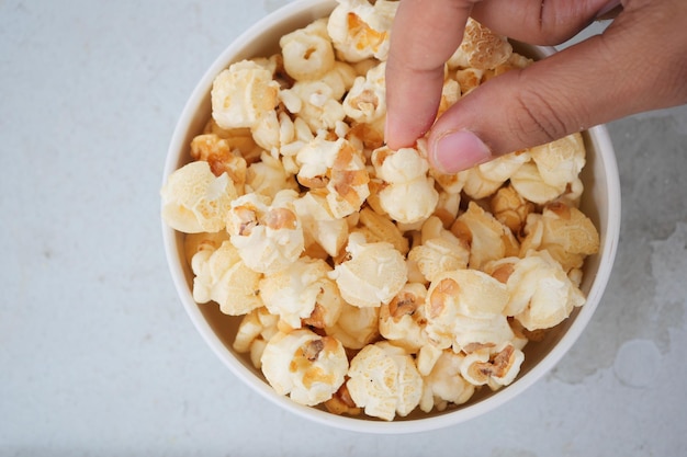 Cueillir à la main du pop-corn dans un bol sur la table