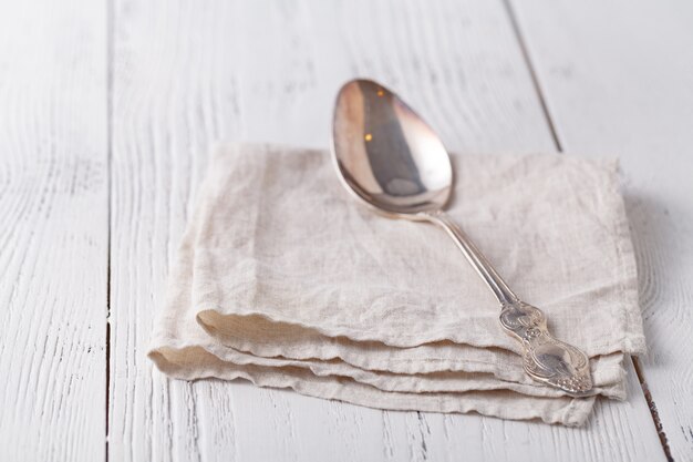 Cuillère en argent sur une serviette sur une table en bois