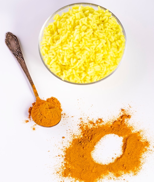 Une cuillère au curcuma et une assiette de riz