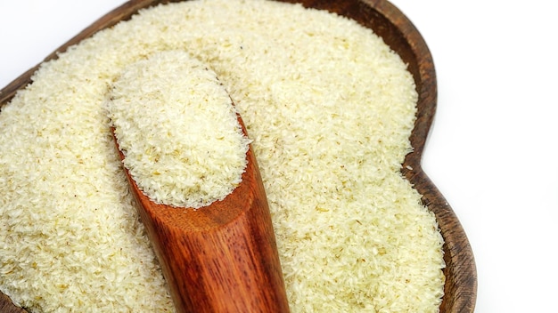 Cuillère en bois avec cosse de psyllium close up sur tas de sucre