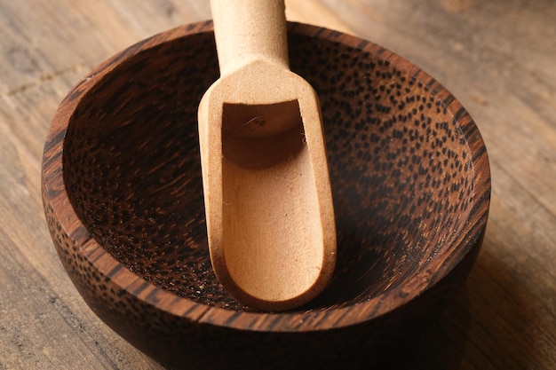 cuillère en bois dans un bol en bois de palmier couverts en matériaux naturels