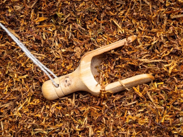 Photo cuillère en bois avec du tabac sec en gros plan