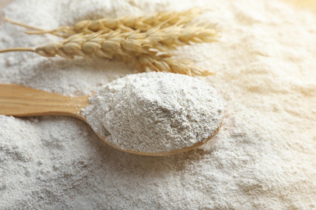 Cuillère en bois sur fond de farine blanche