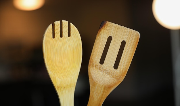 Une cuillère en bois et une spatule en bois sont côte à côte.