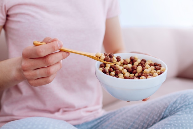 Cuillère et bol remplis de boules de chocolat pour le petit déjeuner aux céréales