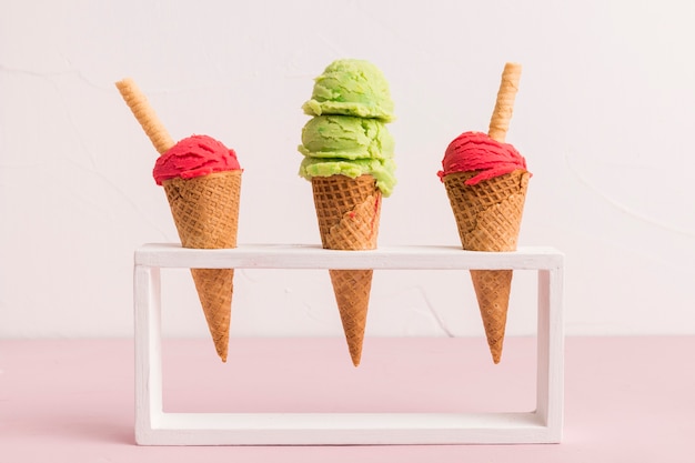 Photo cuillère à crème glacée fraîche dans des cônes avec paille gaufrée sur pied