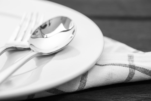 Photo cuillère dans une assiette blanche sur une table en bois se bouchent