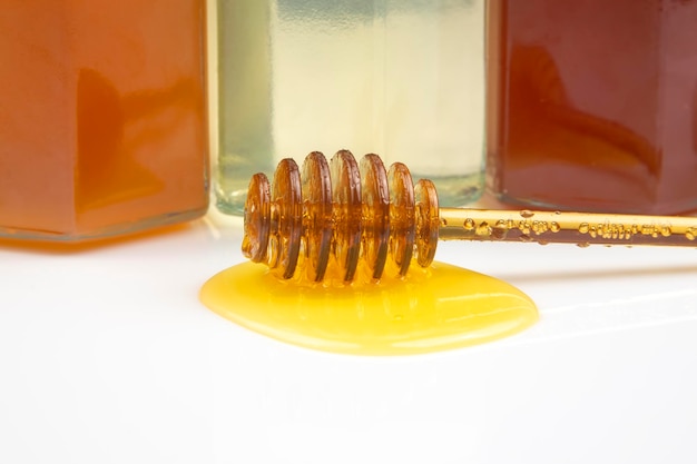 Cuillère avec du miel frais et du pollen sur le fond des pots avec différents types de miel. nourriture vitaminée biologique