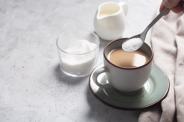 Photo cuillère avec édulcorant sur une tasse de café au lait