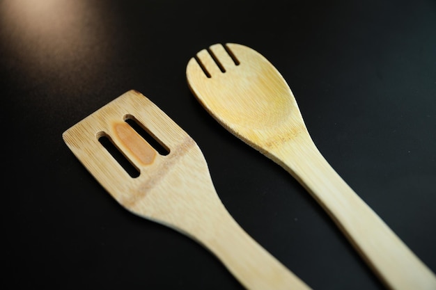 Une cuillère et une fourchette en bois sont côte à côte.