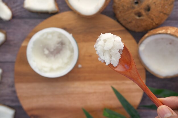 Cuillère à l'huile de noix de coco et noix sur fond noir