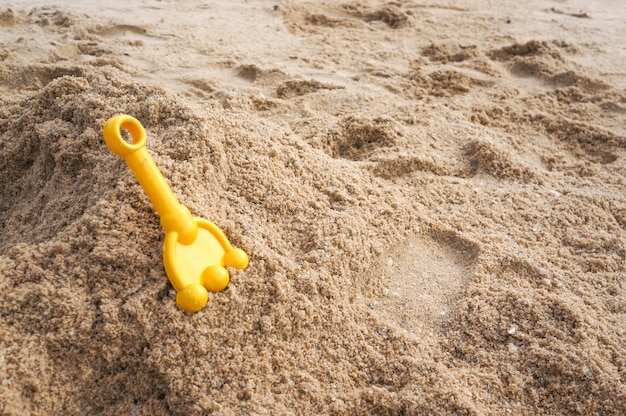 Cuillère jaune pour enfant sur la plage