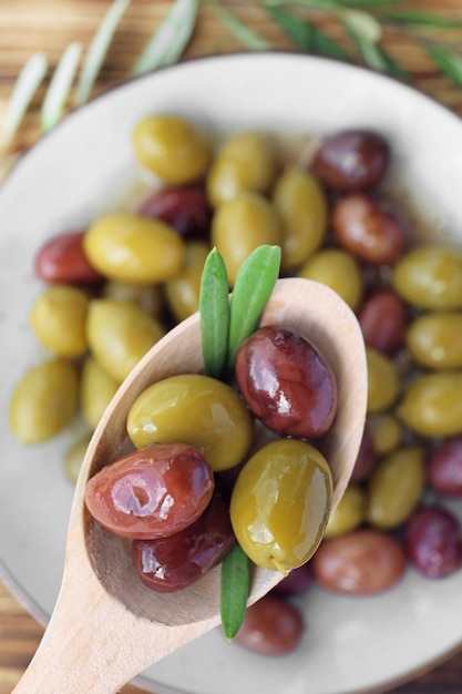 Cuillère à olives en conserve sur plaque close up