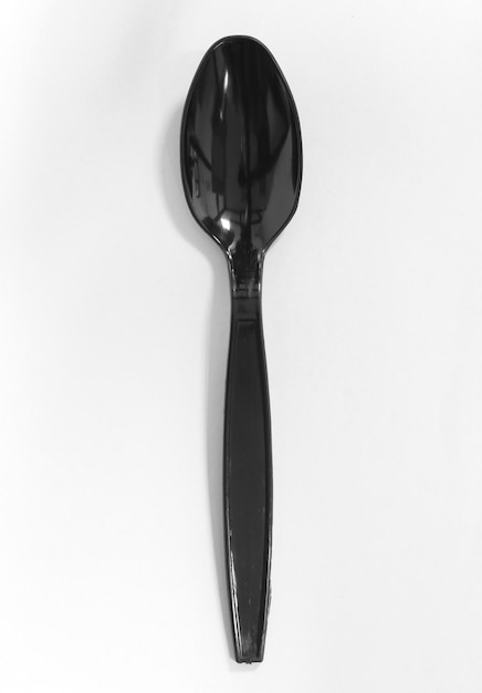 Photo cuillère en plastique noir isolé sur fond blanc