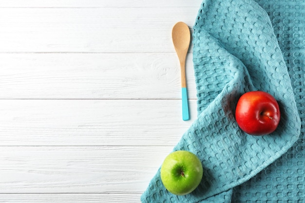 Cuillère à serviette de cuisine propre et fruits sur la vue de dessus de table en bois blanc