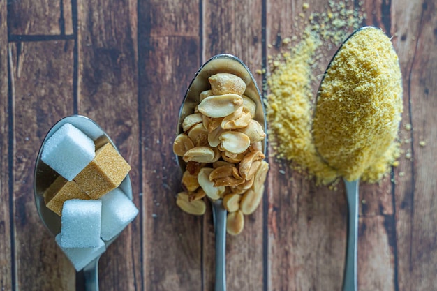 Des cuillères d'arachides garri et de morceaux de sucre combinés pour faire une collation nigériane populaire