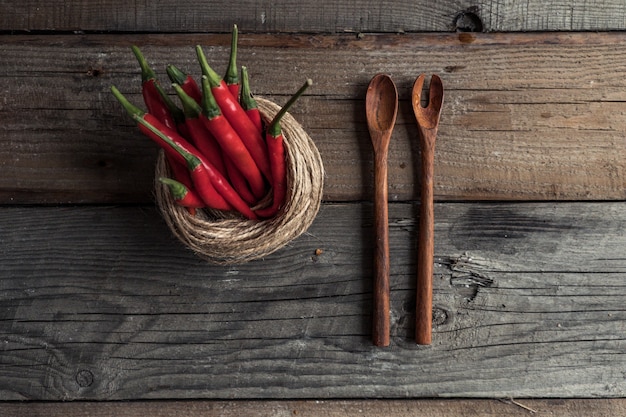 Cuillères d'assaisonnements sur une table en bois avec des assaisonnements éparpillés dessus