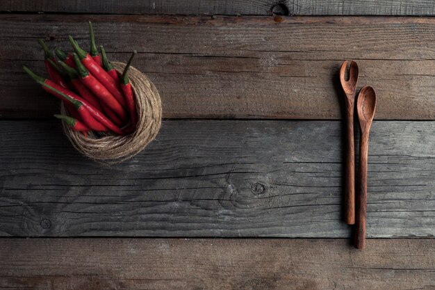 Cuillères d'assaisonnements sur une table en bois avec des assaisonnements éparpillés dessus