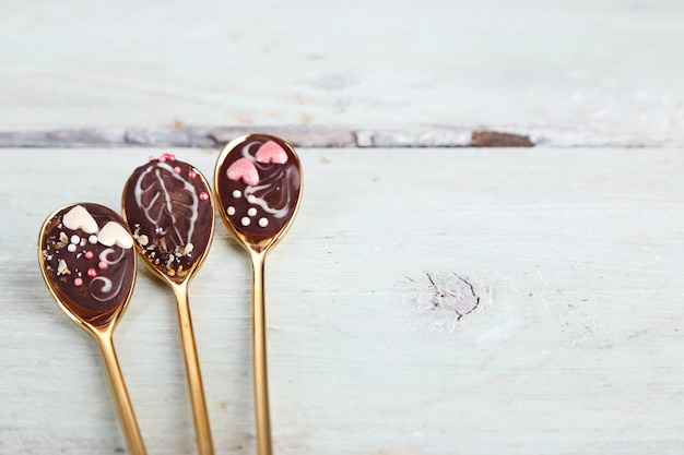 Cuillères à chocolat savoureux pour la fête sur une vieille table en bois