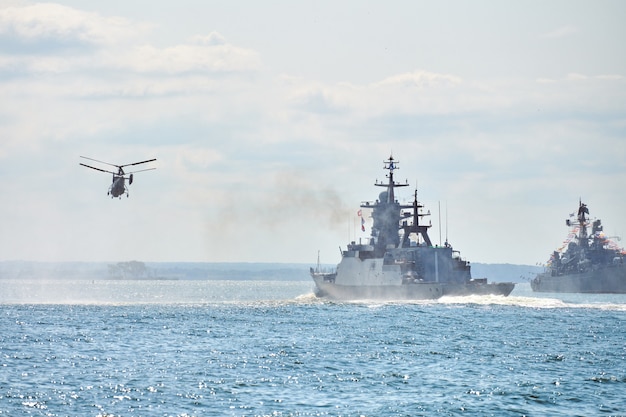 Cuirassés navires de guerre corvette lors d'exercices navals et manœuvres d'hélicoptères au-dessus de l'eau en mer Baltique. Les navires de guerre, les hélicoptères et les bateaux effectuent des tâches en mer, les navires de guerre militaires naviguent, la marine russe