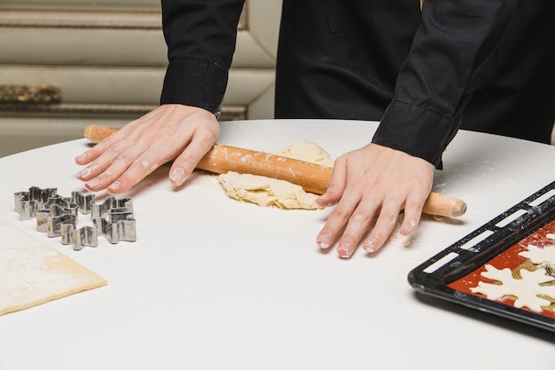 Cuire le chef roule la pâte pour les biscuits.