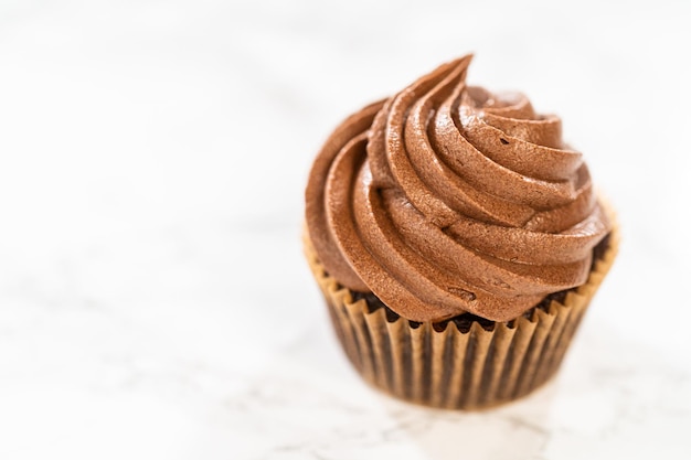 Photo cuire des cupcakes au chocolat avec du glaçage au chocolat décadent