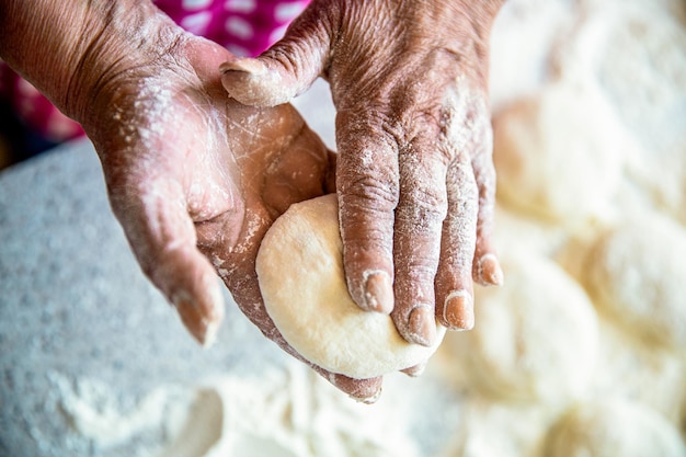 Cuire la pâte pour cuire des morceaux de pâte crue Pâte à gâteaux faite maison dans les mains des femmes Processus de fabrication des tartes à la main Pâte à tarte mains Mains de femme roulant des pâtes pour tartes Cuisson à la maison