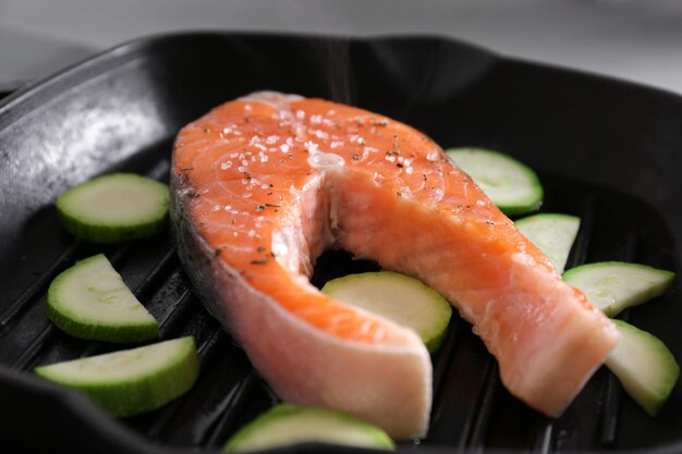 Cuire le steak de saumon et les courgettes sur la lèchefrite