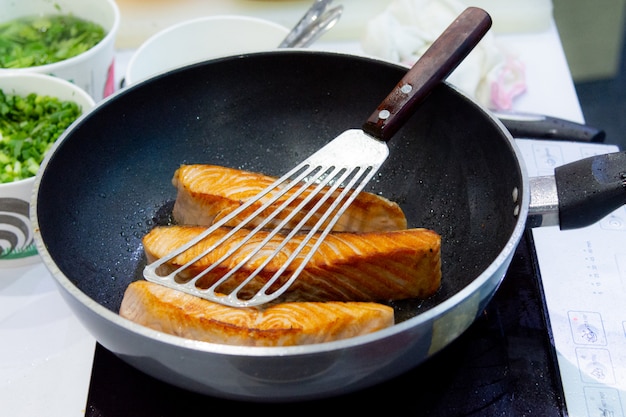Photo cuire un steak de saumon avec une poêle, faire frire un steak de saumon
