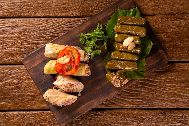 Cuisine arabe. Petits pains de chou appétissants et riz et menthe enveloppés dans des feuilles de vigne sur fond de bois.