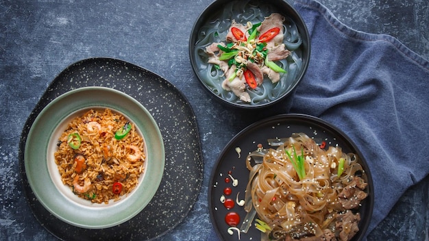 Cuisine asiatique, nouilles asiatiques épicées de boeuf, Pho Bo et riz de fruits de mer sur l'obscurité