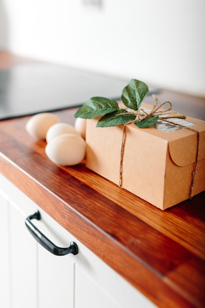 Cuisine blanche avec des oeufs et boîte-cadeau Carte de Joyeuses Pâques avec des oeufs en bois