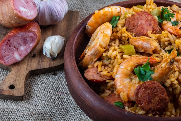 Cuisine cajun. Jambalaya rouge avec gros plan de crevettes, légumes et saucisses. Mise au point sélective.