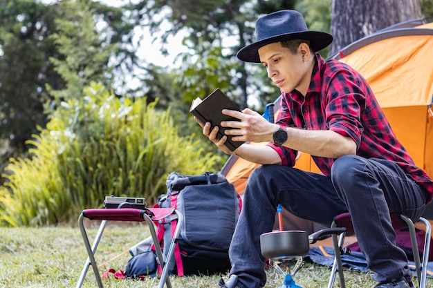Cuisine Camping et lecture Le jeune homme profite des grands espaces